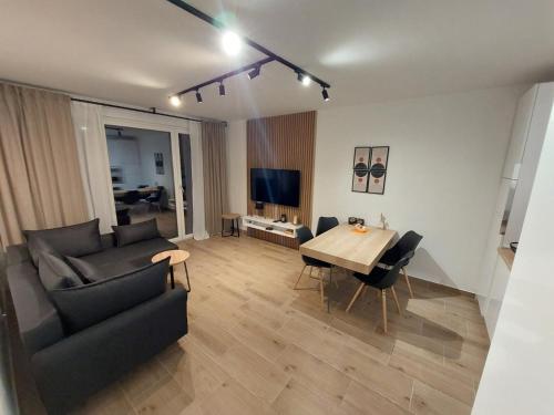 a living room with a couch and a table at Apartman SRNA, Vila JEZERO in Divčibare