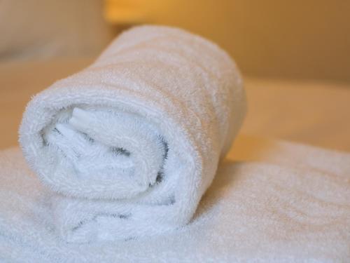 a roll of white towels sitting on top of a bed at Cosy Cottage in Potto