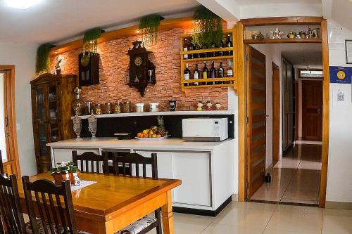 une cuisine avec une table et un comptoir dans l'établissement Pousada Gianisella, à Bom Jardim da Serra