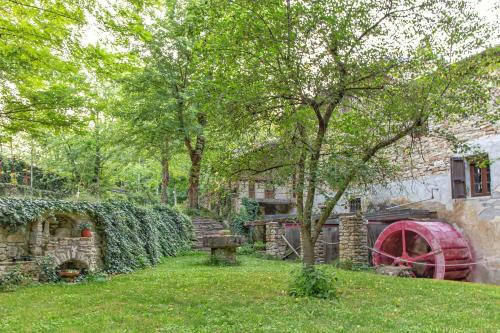 a yard with a stone building and a tree at Mulino del Lentino in Nibbiano