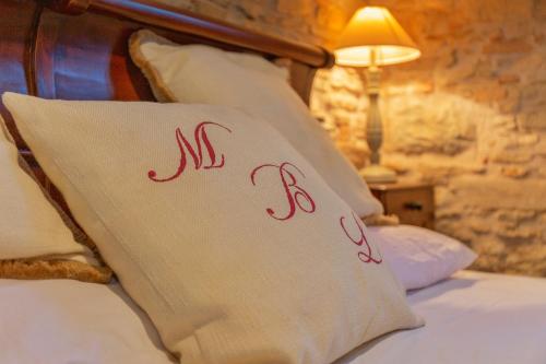 a bed with a pillow with the word kiss on it at Mulino del Lentino in Nibbiano