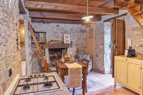 a kitchen with a stove and a stone wall at Mulino del Lentino in Nibbiano