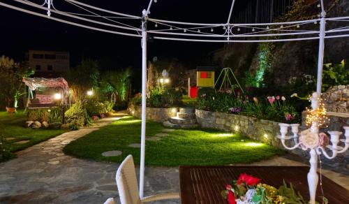 a garden at night with a table and lights at Casa Vacanze Family in Albisola Superiore