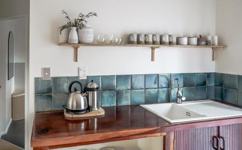 a kitchen counter with a tea kettle and a sink at La Dolce Vita Whangamata in Whangamata