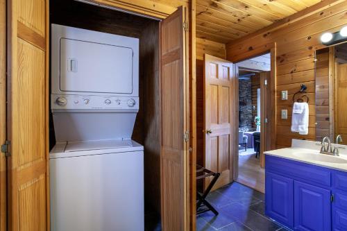 Waschmaschine und Trockner im Bad mit Waschbecken in der Unterkunft Constellation Station View Hot Tub Fireplace in Gatlinburg