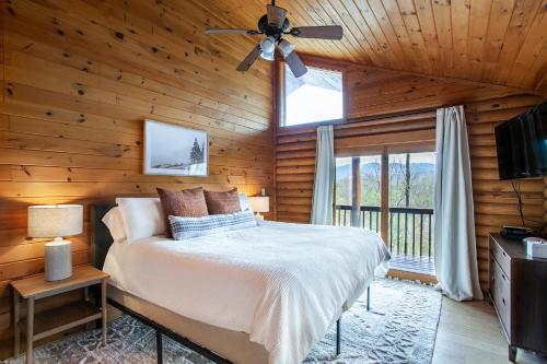 ein Schlafzimmer mit Bett und Deckenventilator in der Unterkunft Constellation Station View Hot Tub Fireplace in Gatlinburg