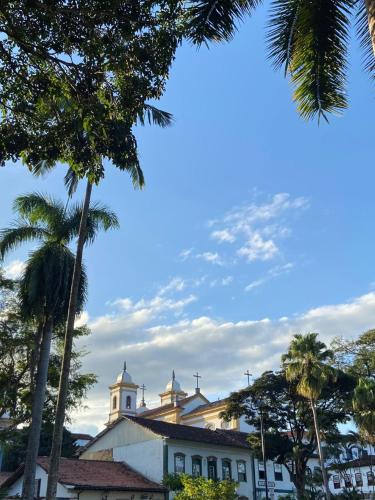 a building with a clock tower and palm trees at Pousada do Chafariz in Mariana