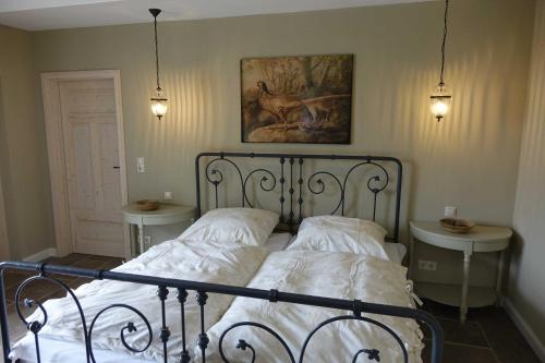 a bed in a bedroom with two tables and a painting at B&B Angeliter Landidyll in Gelting
