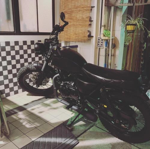 a black motorcycle parked in front of a house at Otohaya Guesthouse in Nagoya