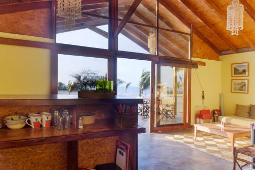 sala de estar con ventana grande y mesa en Wallac Bungalows Canoas de Punta Sal, en Canoas de Punta Sal