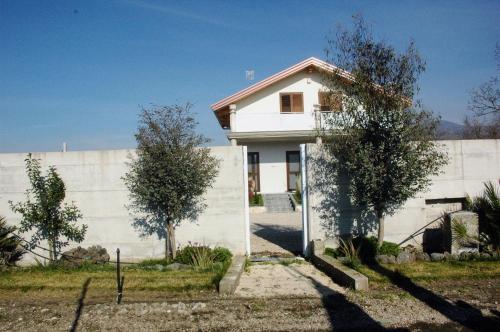 a white house in front of a wall at B&B Desea in Poggiomarino