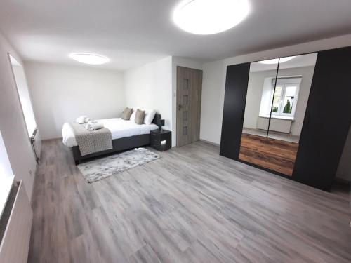 ein Schlafzimmer mit einem Bett und einem großen Spiegel in der Unterkunft VDT Vacances in Môtiers