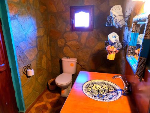 a stone bathroom with a sink and a toilet at Auberge restaurant Afoud in Agoudal