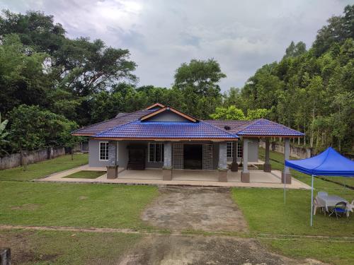 a house with a blue tiled roof at Evergreen Xperience Guest House in Kuala Kubu Baharu