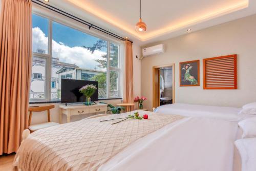 a bedroom with a large bed and a large window at Blue Sea Hotel in Dali
