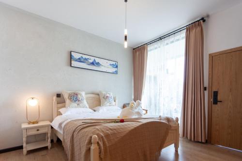 a bedroom with a bed with a stuffed animal on it at Blue Sea Hotel in Dali