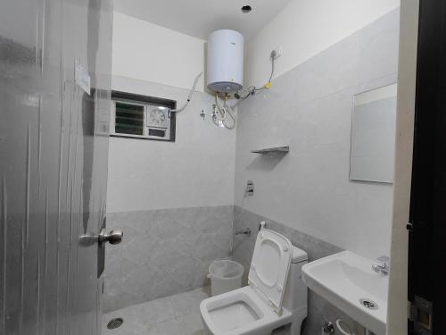 a small bathroom with a toilet and a sink at The Jugglers Rest in Mysore