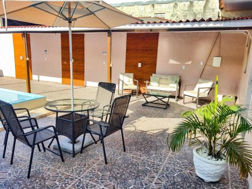 a patio with chairs and a table and an umbrella at Residencial Napolitan in Manaus