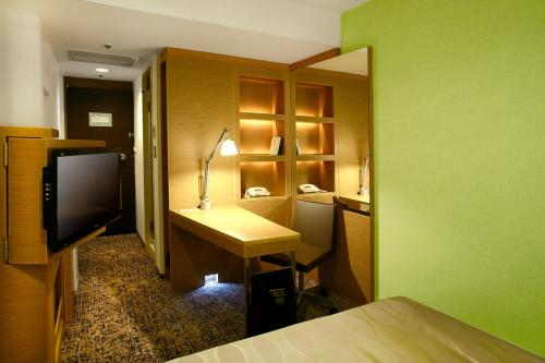 Tempat tidur dalam kamar di CYPRESS HOTEL Nagoya-eki Mae