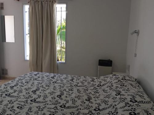 een slaapkamer met een bed met een zwart-witte deken bij FRENTE a TERMAS in Federación