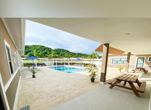 a swimming pool with a picnic table and a bench at Natty’s Cozy Beach house in Hanover Jamaica in Point