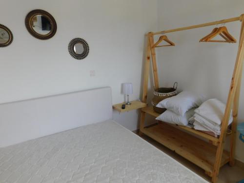 een slaapkamer met een bed en een plank met kussens bij ASTYSTUDIO in Astypalaia-stad (Chora)