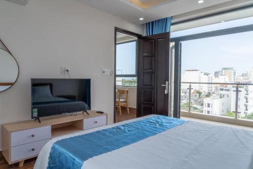 a bedroom with a bed and a large window at Camellia Family Suites in Da Nang