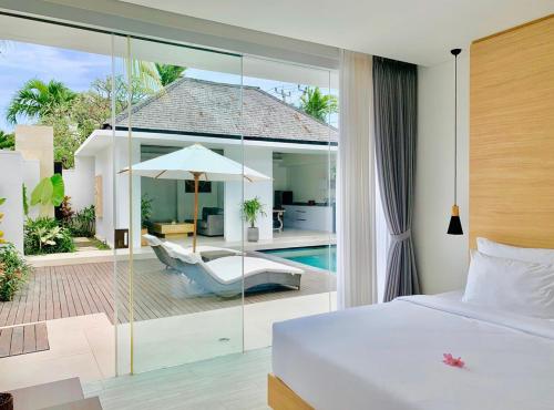 a bedroom with a bed and a patio with a pool at Alami Luxury Villa in Seminyak
