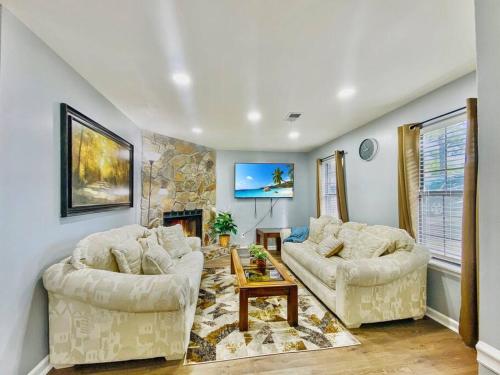 a living room with two couches and a fireplace at NEW! Luxe Cottage with Big Backyard 10 Mi to Augusta in Evans