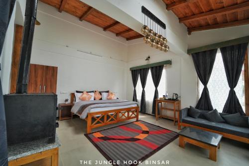 a bedroom with a bed and a fireplace at The Jungle Hook Binsar in Almora