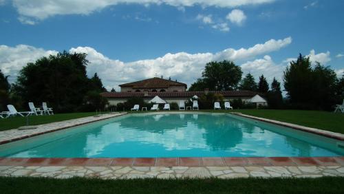 a large swimming pool in front of a house at Il Canto del Sole in Monteroni dʼArbia
