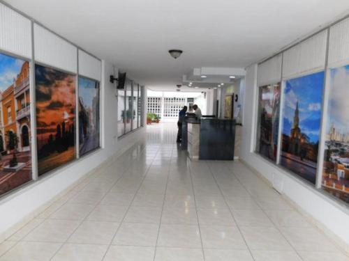 un couloir orné de peintures sur les murs d'un bâtiment dans l'établissement Apartamento amoblado en Bocagrande - Cartagena de Indias, à Carthagène des Indes