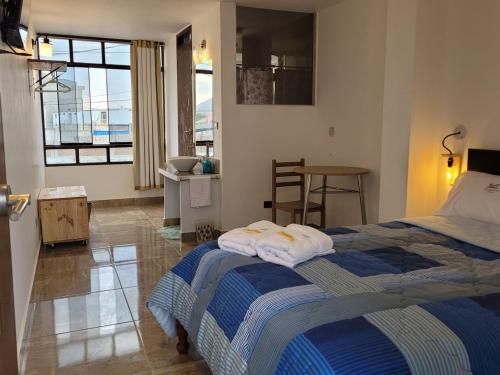 1 dormitorio con 1 cama con toallas en TUPANANCHIKAMA, en Puerto Chicama