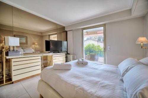 une chambre avec un grand lit blanc et une télévision dans l'établissement IMMOGROOM - 2 BR - Air conditioning - Wifi - Terrace - Common parking, à Cannes