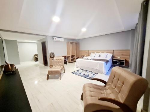 - une chambre avec un lit et un salon avec un canapé dans l'établissement Royal Hotel, à Tailandia