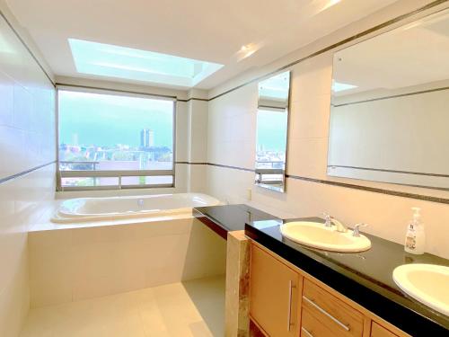 a bathroom with two sinks and a tub and a window at Topacio7 Residencial in Boca del Río
