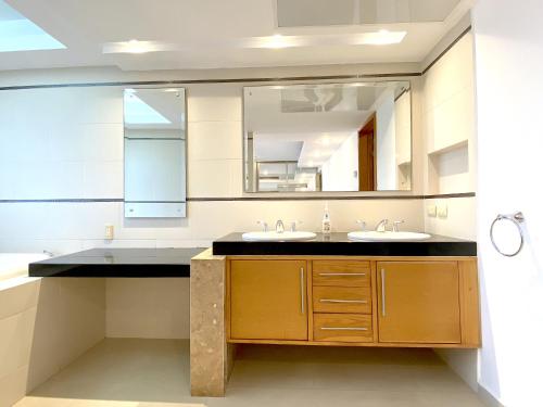 博卡德爾里奧的住宿－Topacio7 Residencial，一间带两个盥洗盆和大镜子的浴室