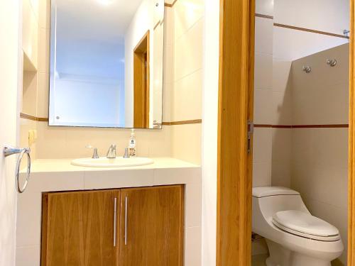 a bathroom with a sink and a toilet and a mirror at Topacio7 Residencial in Boca del Río