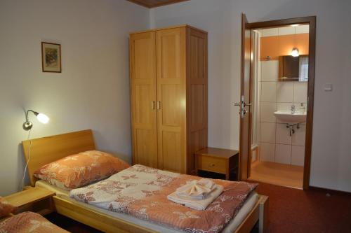 a bedroom with a bed and a bathroom with a sink at Penzion Farma Dvorec in Radnice