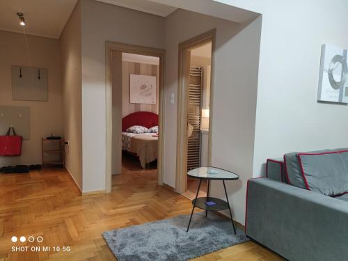 ein Wohnzimmer mit einem Sofa und einem Bett in der Unterkunft Cozy apartment near the sea in Palaio Faliro in Athen