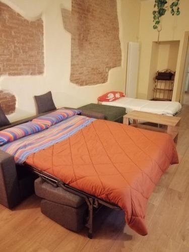 a bed with an orange comforter in a room at Nuovo Borgo - posizione ideale per visitare l'Umbria, Perugia, Assisi e le altre località in Deruta