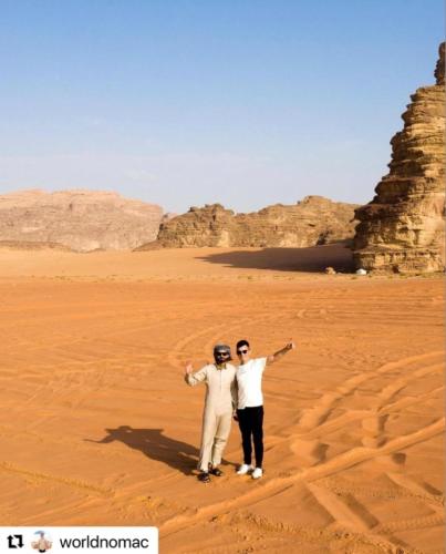 two men standing in the desert with their arms out at Rum Jordan camp and tours in Wadi Rum