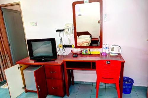 a red desk with a television and a mirror at The Room Concept Homestay in Kuah