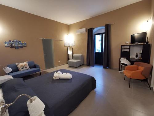a hotel room with a bed and a living room at Hercules Suites in Noto