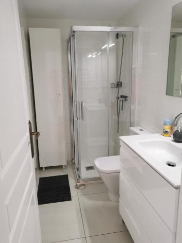 a white bathroom with a shower and a toilet at Apartamento Albimar in Albir