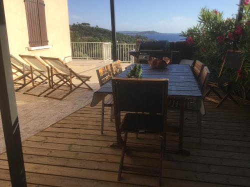 une terrasse en bois avec une table et des chaises dessus dans l'établissement Villa de la Plage, à Grosseto-Prugna