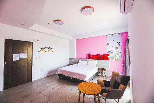 een hotelkamer met een bed en een tafel en stoelen bij 澎湖金宿喜民宿Penghu Comfy B&B in Magong