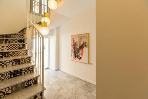 eine Treppe in einem Haus mit einem Gemälde an der Wand in der Unterkunft CasAunoE Boutique Hotel in Olbia