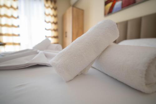 a couple of rolled up towels on a bed at Hotel Zanzi in Durrës