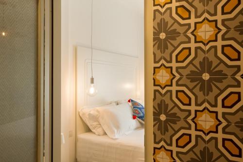 a bedroom with a bed and a wall with a mirror at CasAunoE Boutique Hotel in Olbia